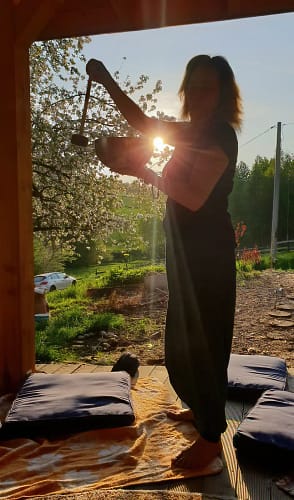 Beata Sypniewska trzymająca misę przy zachodzie słońca